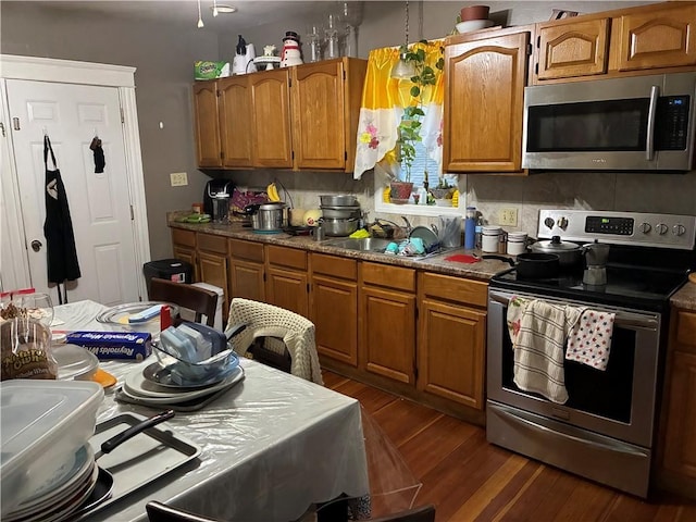 121 Murray St, Providence, RI 02909 - kitchen featuring appliances with stainless steel finishes, dark wood-style floors, and brown cabinets
