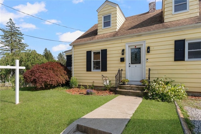 4 Linwood St, West Warwick, RI 02893 - view of exterior entry with a yard, a shingled roof, and a chimney