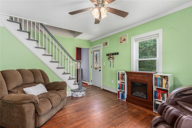4 Linwood St, West Warwick, RI 02893 - living area featuring baseboard heating, wood finished floors, a fireplace, ornamental molding, and a ceiling fan