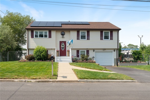 17 Cedar Dr, West Warwick, RI 02893 - split foyer home featuring an attached garage, roof mounted solar panels, and asphalt driveway