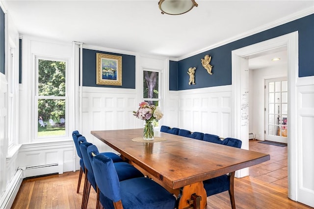 214 Highland Rd, Tiverton, RI 02878 - dining area featuring a decorative wall, a wainscoted wall, a baseboard heating unit, wood finished floors, and baseboard heating