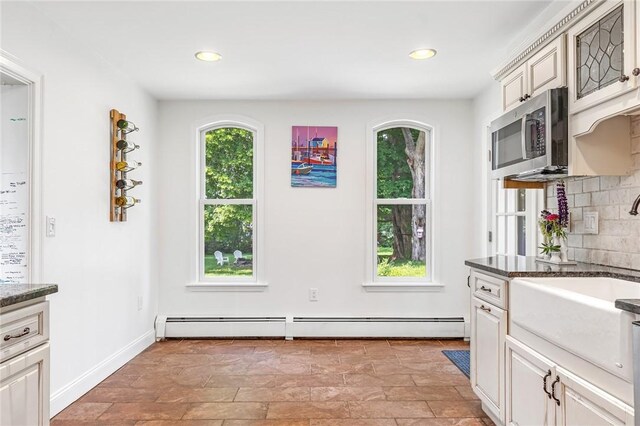 214 Highland Rd, Tiverton, RI 02878 - kitchen featuring stainless steel microwave, a baseboard heating unit, decorative backsplash, recessed lighting, and dark stone counters