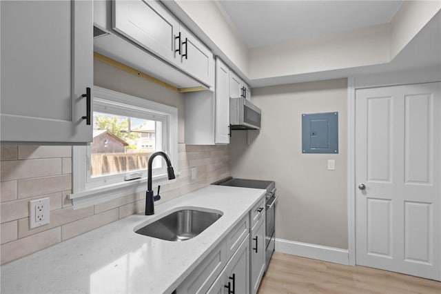 233 Waterman Ave, East Providence, RI 02914 - kitchen with electric panel, high end stainless steel range, light wood-type flooring, light stone countertops, and decorative backsplash