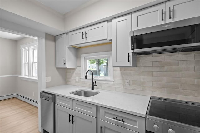 233 Waterman Ave, East Providence, RI 02914 - kitchen featuring appliances with stainless steel finishes, light countertops, decorative backsplash, and light wood finished floors