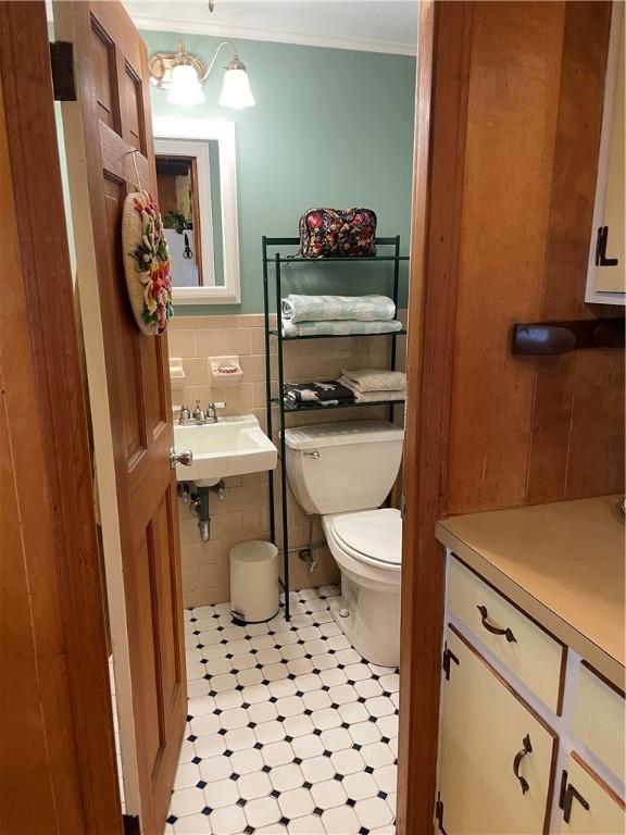 37 Kermit St, Woonsocket, RI 02895 - half bath featuring tile walls, ornamental molding, and tile patterned flooring