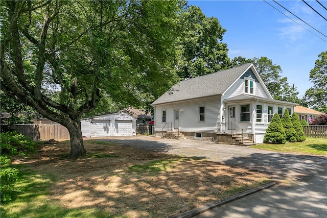 35 Inman Ave, Warwick, RI 02886 - view of front of property with an outbuilding, entry steps, a detached garage, a shingled roof, and dirt driveway