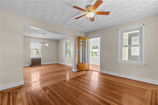35 Inman Ave, Warwick, RI 02886 - unfurnished living room with radiator heating unit, a chandelier, wood finished floors, and ceiling fan