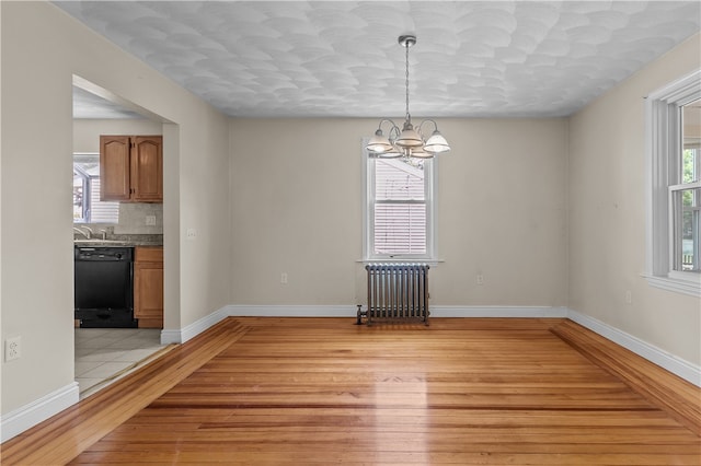 35 Inman Ave, Warwick, RI 02886 - empty room with radiator, light wood-style flooring, and a chandelier