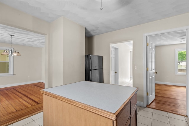 35 Inman Ave, Warwick, RI 02886 - kitchen featuring freestanding refrigerator, light tile patterned floors, a chandelier, pendant lighting, and light countertops