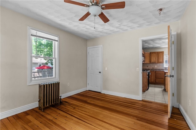35 Inman Ave, Warwick, RI 02886 - unfurnished room with radiator, light wood-style flooring, ceiling fan, and fire sprinkler in ceiling
