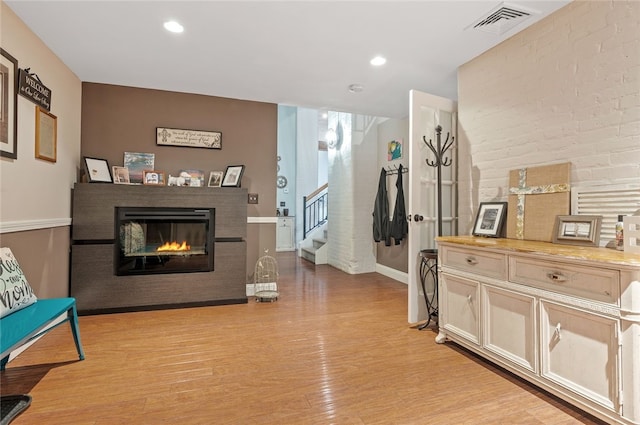 1 Tupperware Dr Unit 115, North Smithfield, RI 02896 - living room with stairs, light wood-style flooring, a multi sided fireplace, and recessed lighting