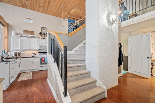 1 Tupperware Dr Unit 115, North Smithfield, RI 02896 - staircase with a towering ceiling, wood finished floors, wooden ceiling, and brick wall