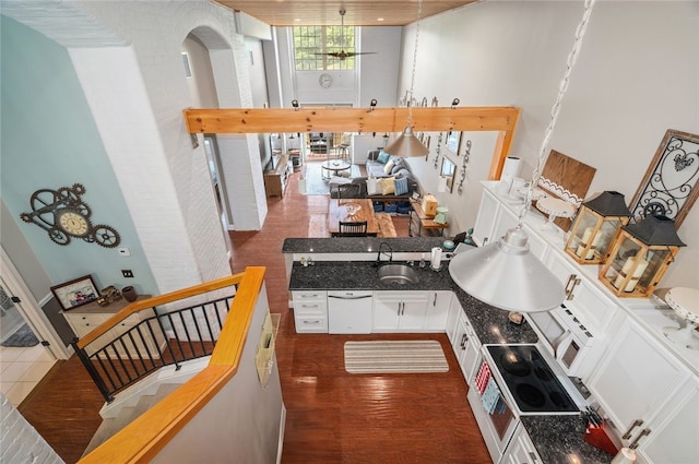 1 Tupperware Dr Unit 115, North Smithfield, RI 02896 - kitchen with white cabinetry, a towering ceiling, arched walkways, dark wood-style floors, and stove