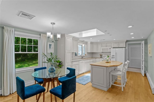 55 Atherton Rd, East Greenwich, RI 02818 - dining room with light wood-type flooring, recessed lighting, a chandelier, and a skylight