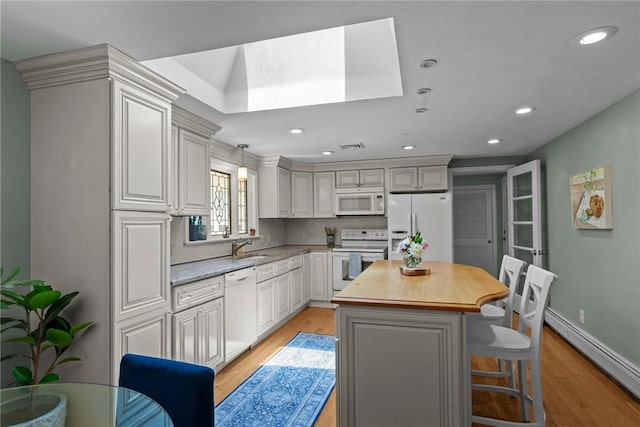 55 Atherton Rd, East Greenwich, RI 02818 - kitchen with white appliances, a baseboard radiator, light wood-style flooring, a center island, and recessed lighting