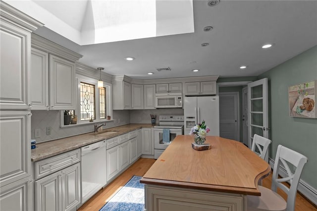 55 Atherton Rd, East Greenwich, RI 02818 - kitchen featuring white appliances, light wood-style flooring, a kitchen island, decorative backsplash, and recessed lighting