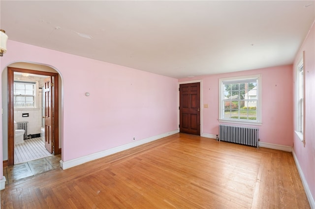 53 Overland Ave, Cranston, RI 02910 - spare room featuring radiator, arched walkways, and light wood-style flooring