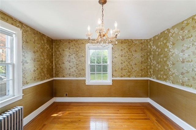 53 Overland Ave, Cranston, RI 02910 - unfurnished dining area with radiator, a chandelier, light wood-style floors, and wainscoting