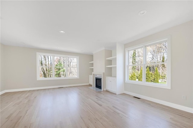 0 Freedom Trail Dr, Portsmouth, RI 02871 - unfurnished living room featuring healthy amount of natural light, light wood-style floors, a fireplace with flush hearth, recessed lighting, and built in shelves