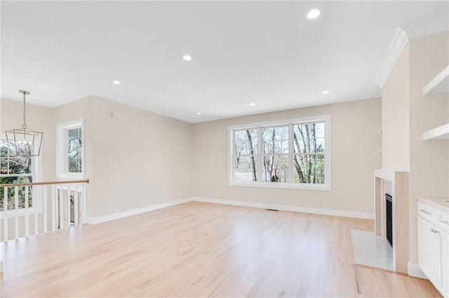 0 Freedom Trail Dr, Portsmouth, RI 02871 - unfurnished living room with a chandelier, a fireplace with flush hearth, light wood-type flooring, and recessed lighting