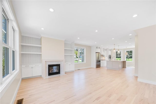 0 Freedom Trail Dr, Portsmouth, RI 02871 - unfurnished living room featuring light wood-type flooring, a high end fireplace, recessed lighting, crown molding, and built in shelves