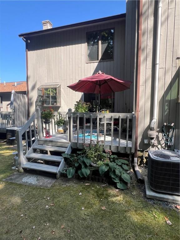 64 Kristee Cir Unit 64, West Warwick, RI 02893 - back of property with a wooden deck and a chimney