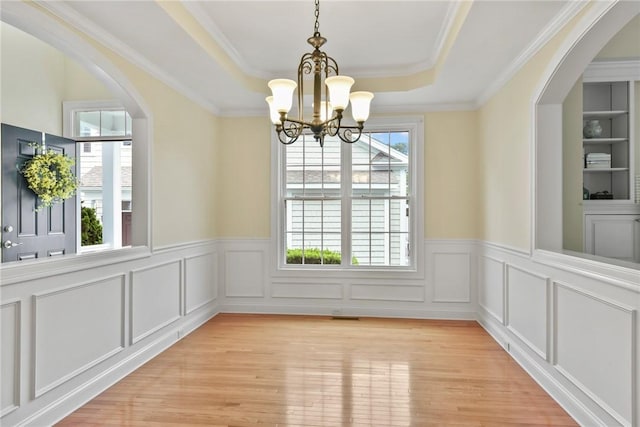 99 Preservation Way S, Kingstown, RI 02879 - unfurnished dining area with a chandelier, a raised ceiling, wainscoting, arched walkways, and light wood-style flooring