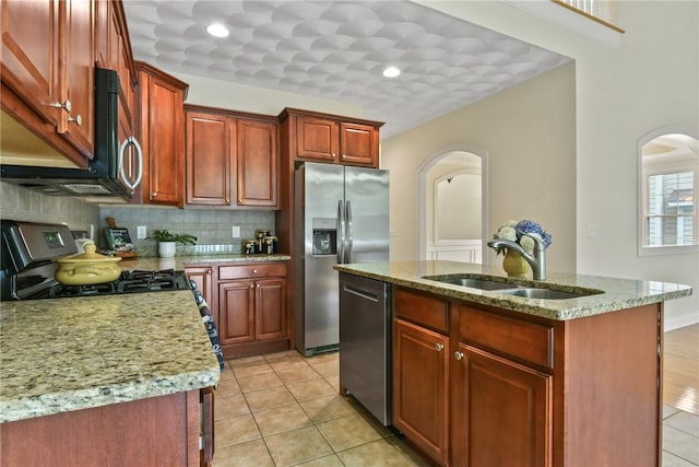 99 Preservation Way S, Kingstown, RI 02879 - kitchen with stainless steel appliances, arched walkways, tasteful backsplash, a center island with sink, and light stone countertops