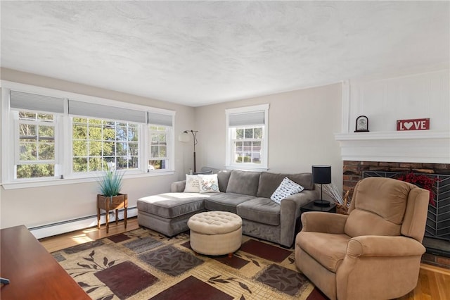 1 Adelaide Ave, Bristol, RI 02809 - living room with a baseboard radiator, wood finished floors, and a brick fireplace