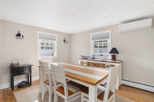 1 Adelaide Ave, Bristol, RI 02809 - dining space with a wall mounted air conditioner, a baseboard heating unit, and light wood-style floors