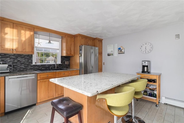 1 Adelaide Ave, Bristol, RI 02809 - kitchen featuring appliances with stainless steel finishes, tasteful backsplash, light wood-style flooring, and a kitchen breakfast bar