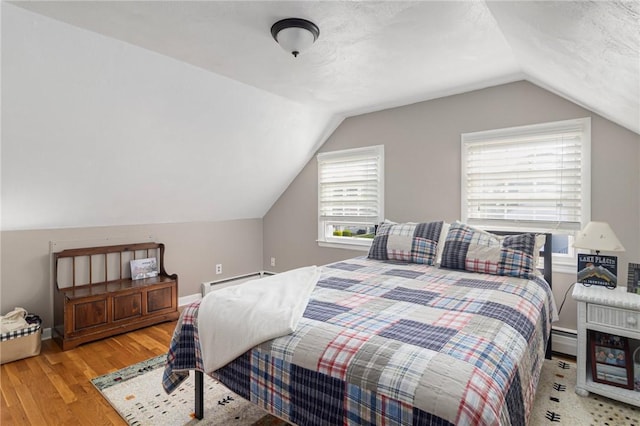 1 Adelaide Ave, Bristol, RI 02809 - bedroom with wood finished floors, a baseboard radiator, and lofted ceiling