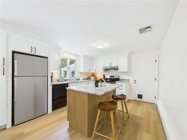 65 Bayberry Ln, East Greenwich, RI 02818 - kitchen featuring freestanding refrigerator, black dishwasher, stainless steel range with electric cooktop, under cabinet range hood, and light wood-style floors