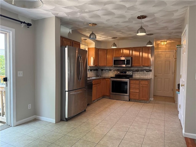 17 Chester Ave, Warwick, RI 02889 - kitchen with appliances with stainless steel finishes, dark countertops, backsplash, brown cabinets, and light tile patterned flooring