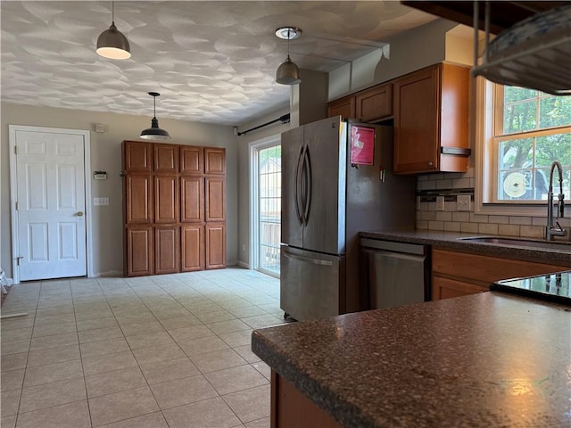 17 Chester Ave, Warwick, RI 02889 - kitchen with dark countertops, brown cabinets, hanging light fixtures, and appliances with stainless steel finishes