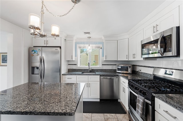 32 Waterman Ave, Johnston, RI 02919 - kitchen featuring appliances with stainless steel finishes, white cabinetry, a chandelier, and dark stone counters