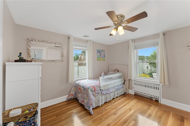 32 Waterman Ave, Johnston, RI 02919 - bedroom with radiator, light wood-type flooring, multiple windows, and a ceiling fan