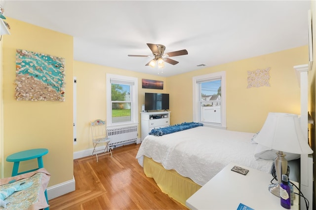 32 Waterman Ave, Johnston, RI 02919 - bedroom featuring radiator heating unit, light wood-style floors, and ceiling fan