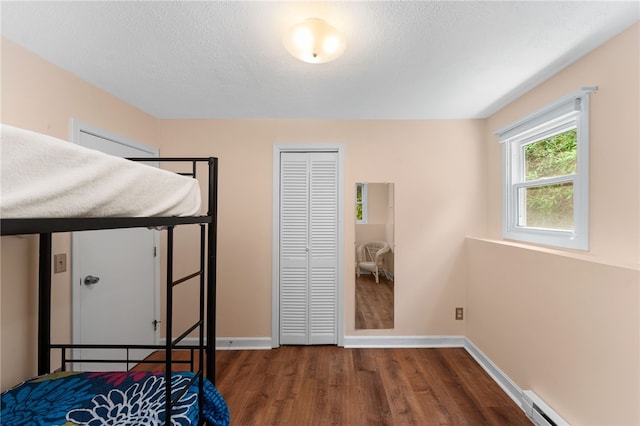 143 Juniper Rd, South Kingstown, RI 02879 - bedroom featuring wood finished floors, a closet, a baseboard radiator, and a textured ceiling