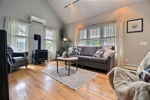 10 N Dr, Westerly, RI 02891 - living room with a wall unit AC, healthy amount of natural light, a wood stove, baseboard heating, and high vaulted ceiling