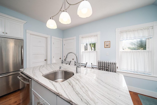 40 Vine St, East Greenwich, RI 02818 - kitchen featuring appliances with stainless steel finishes, dark wood-style floors, decorative light fixtures, light stone counters, and radiator heating unit