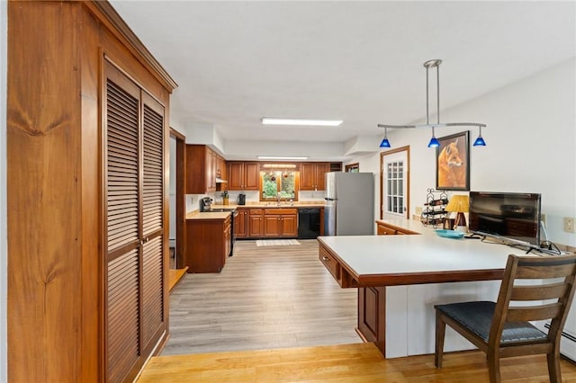 1451 Ministerial Rd, South Kingstown, RI 02879 - kitchen with freestanding refrigerator, light countertops, light wood-type flooring, dishwasher, and brown cabinetry