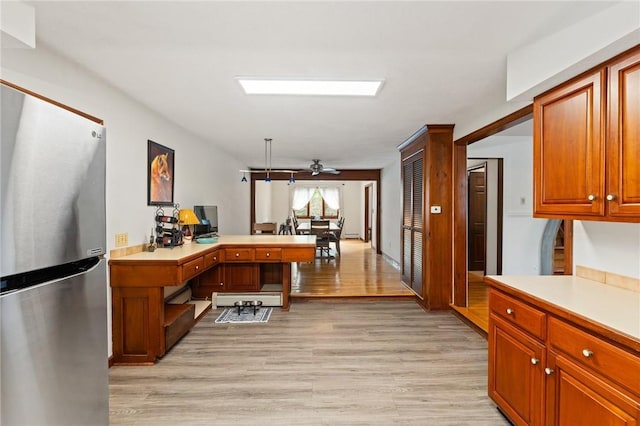 1451 Ministerial Rd, South Kingstown, RI 02879 - kitchen featuring freestanding refrigerator, a peninsula, light countertops, and light wood-style flooring