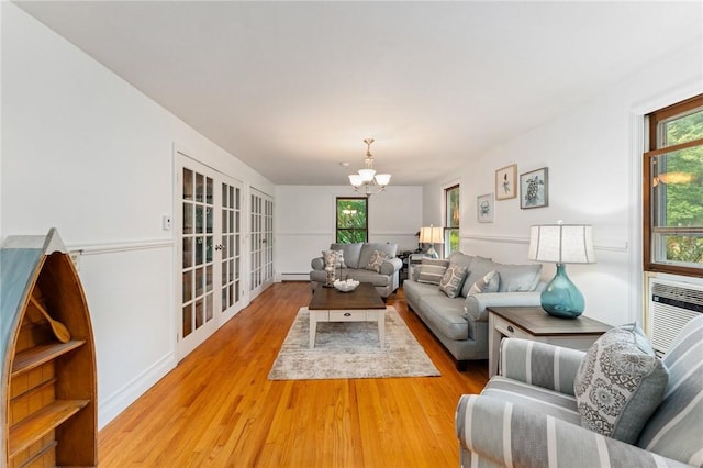 1451 Ministerial Rd, South Kingstown, RI 02879 - living area with a chandelier, plenty of natural light, wood finished floors, and a baseboard radiator