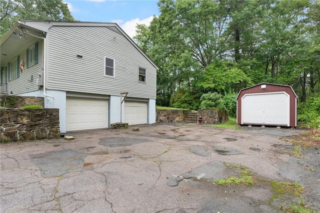 9 Esek Hopkins Rd, Scituate, RI 02857 - view of home's exterior with stucco siding, an outdoor structure, and a garage
