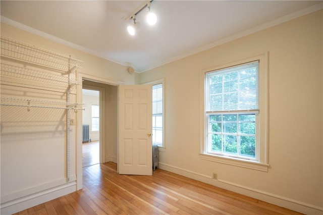 10 Hendricks St, South Kingstown, RI 02879 - unfurnished bedroom with rail lighting, radiator, light wood-style flooring, and crown molding