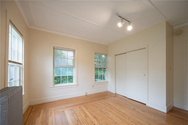 10 Hendricks St, South Kingstown, RI 02879 - unfurnished bedroom with light wood-type flooring, radiator heating unit, a closet, and track lighting