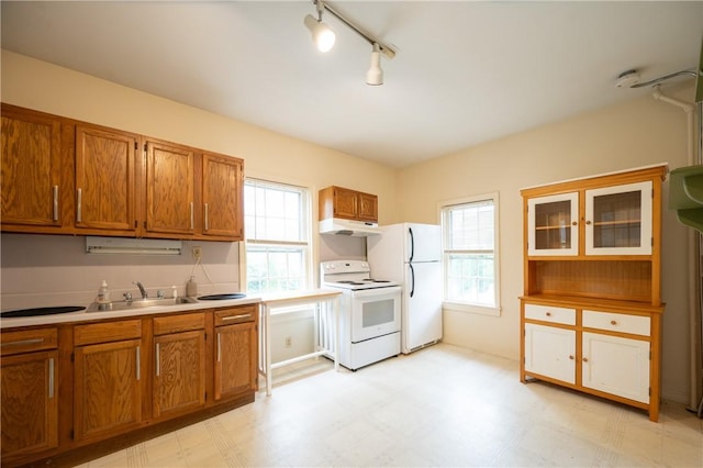 10 Hendricks St, South Kingstown, RI 02879 - kitchen with white appliances, under cabinet range hood, brown cabinetry, and light flooring