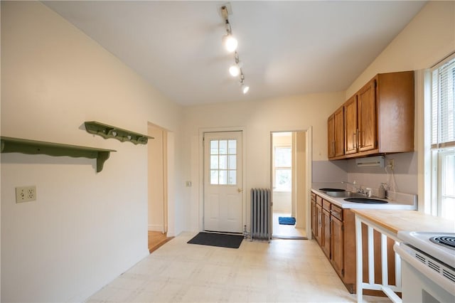 10 Hendricks St, South Kingstown, RI 02879 - kitchen featuring radiator heating unit, brown cabinets, light countertops, and light floors