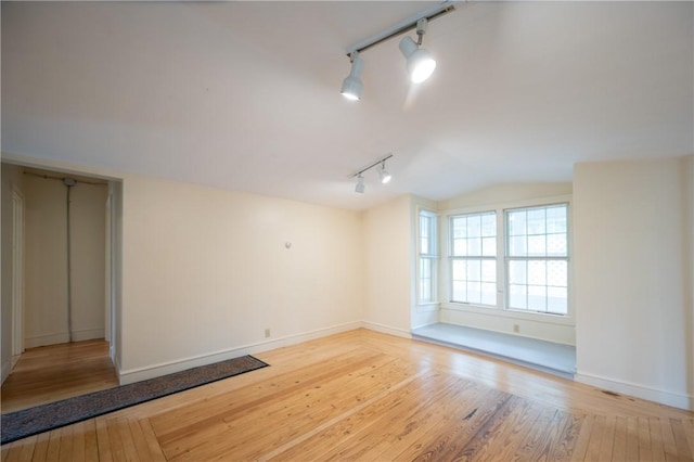 10 Hendricks St, South Kingstown, RI 02879 - unfurnished room featuring rail lighting, hardwood / wood-style flooring, and lofted ceiling